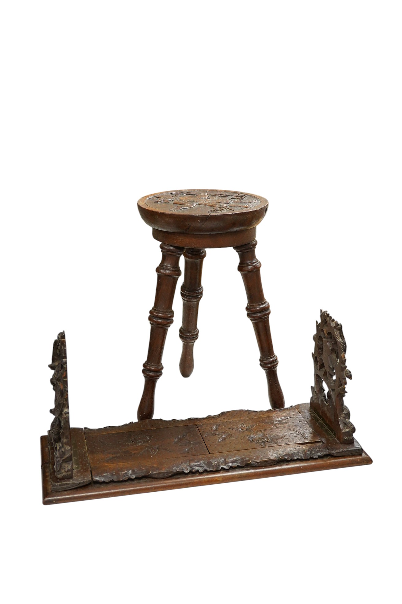 A Black Forest carved book-rack and a commemorative carved oak stool, for the Winchester college emblem, stool 39cm high